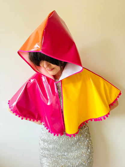 CYCLONE Sunset cape with pink pompoms