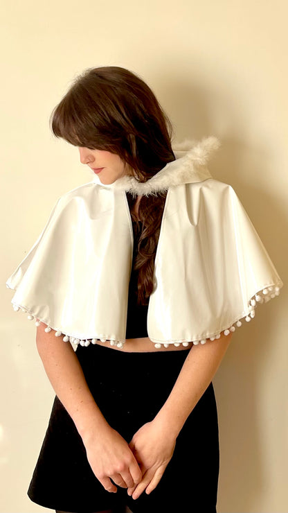 Frosty white 'CYCLONE' cape with feather and pom pom trim