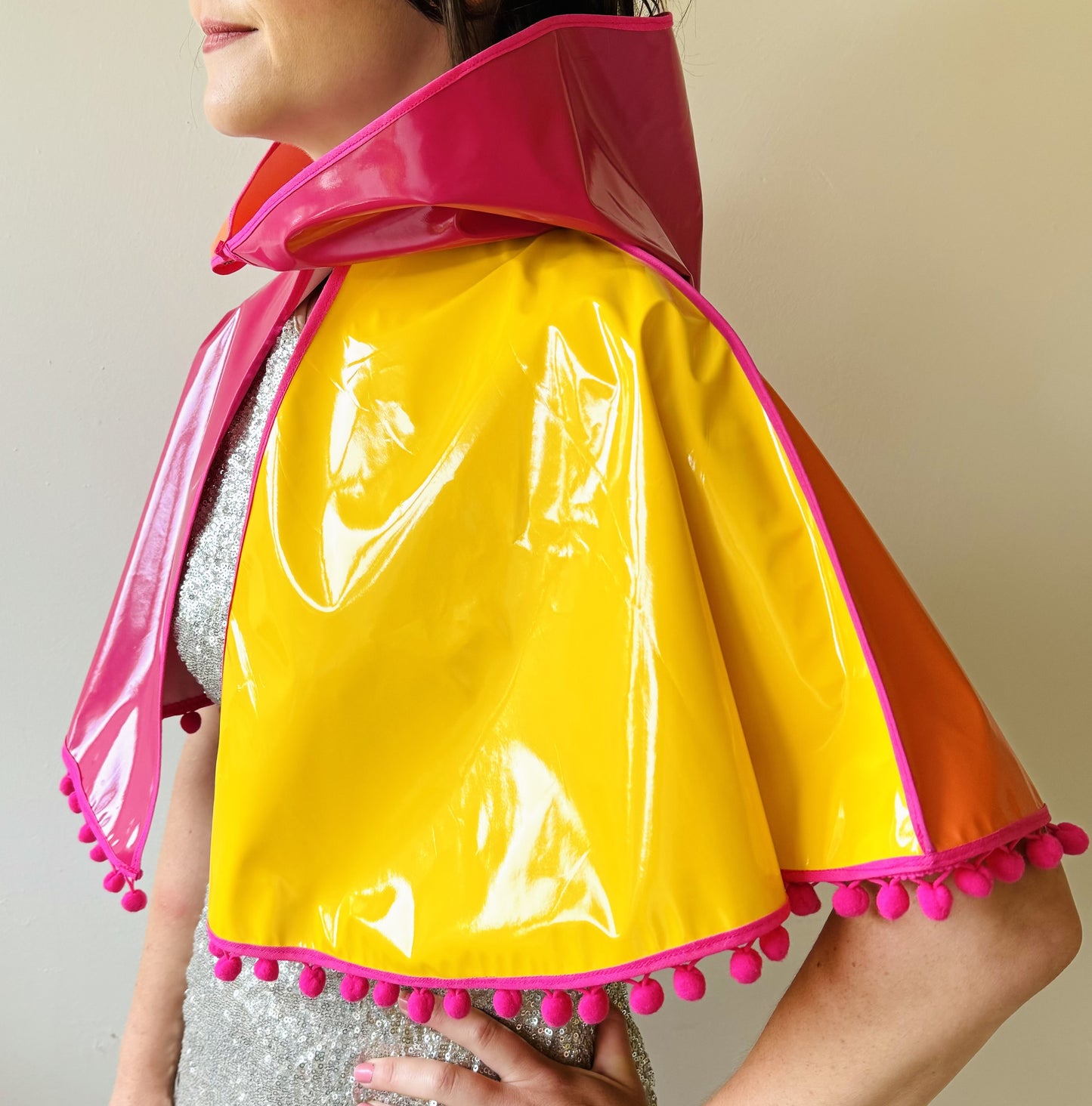 CYCLONE Sunset cape with pink pompoms