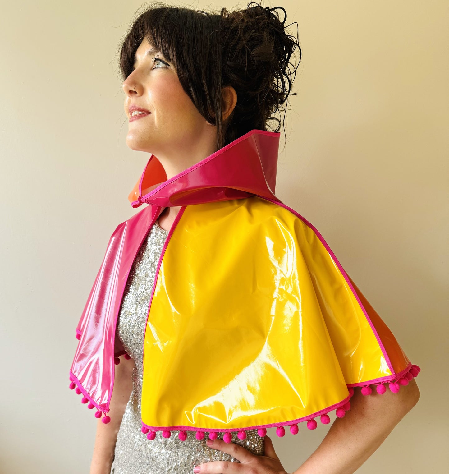 CYCLONE Sunset cape with pink pompoms